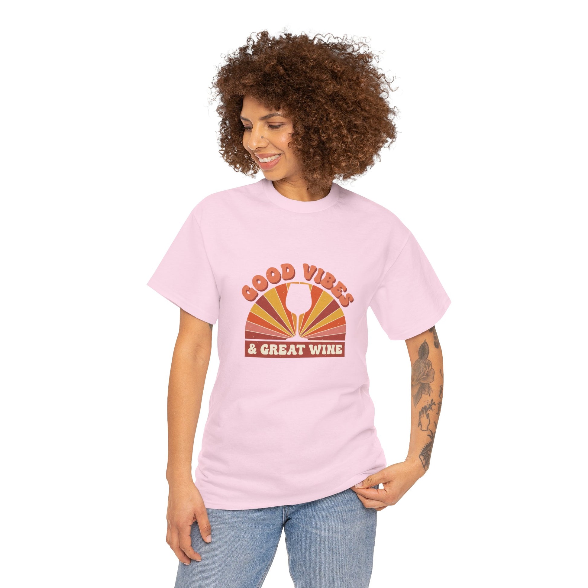 Person wearing pink T-shirt with a vintage graphic that states "good vibes and great wine" and white background