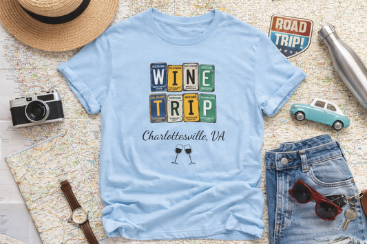 Light blue t-shirt with 'Wine Trip Charlottesville, VA' design on a map with travel-themed items.