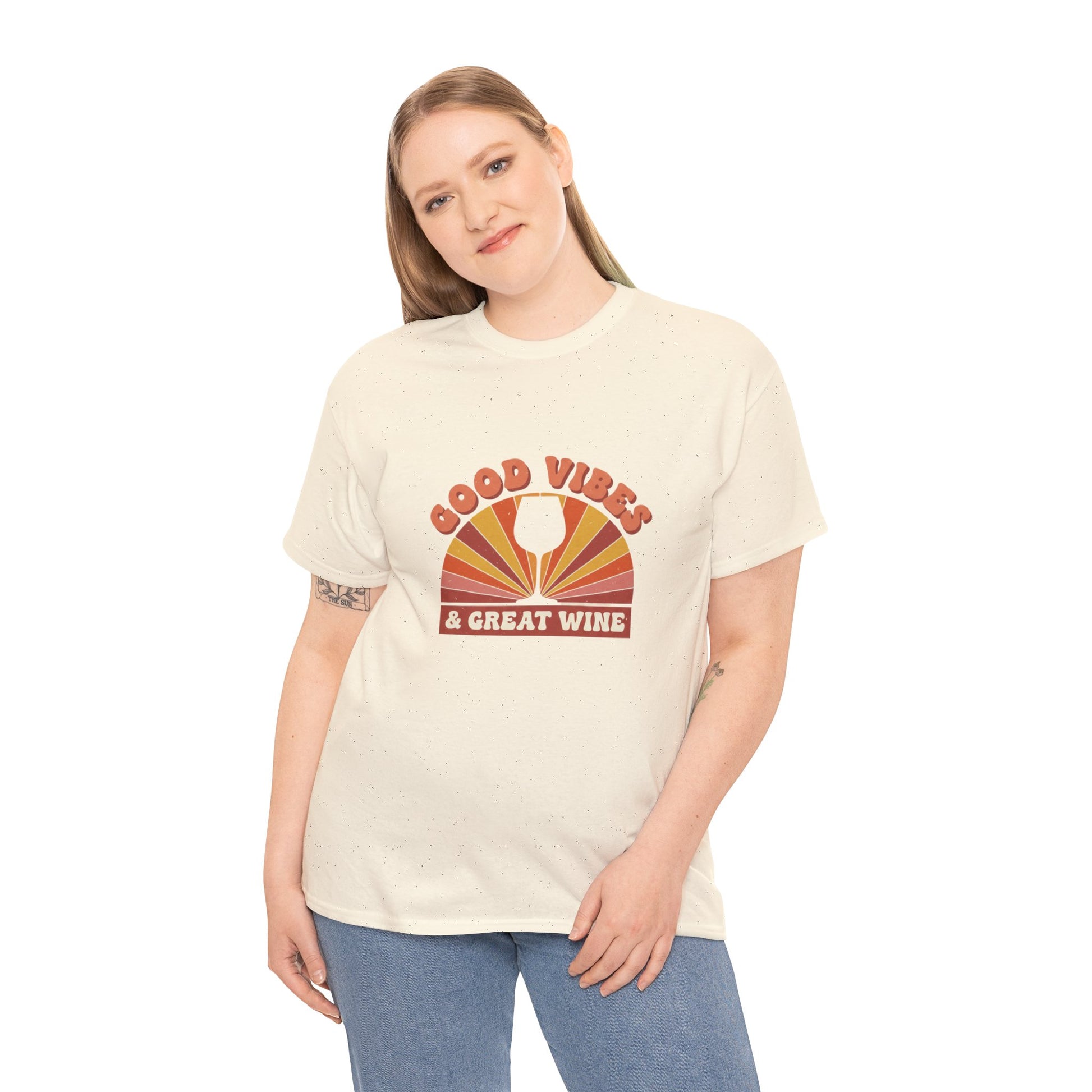 Person wearing natural color T-shirt with a vintage graphic that states "good vibes and great wine" and white background