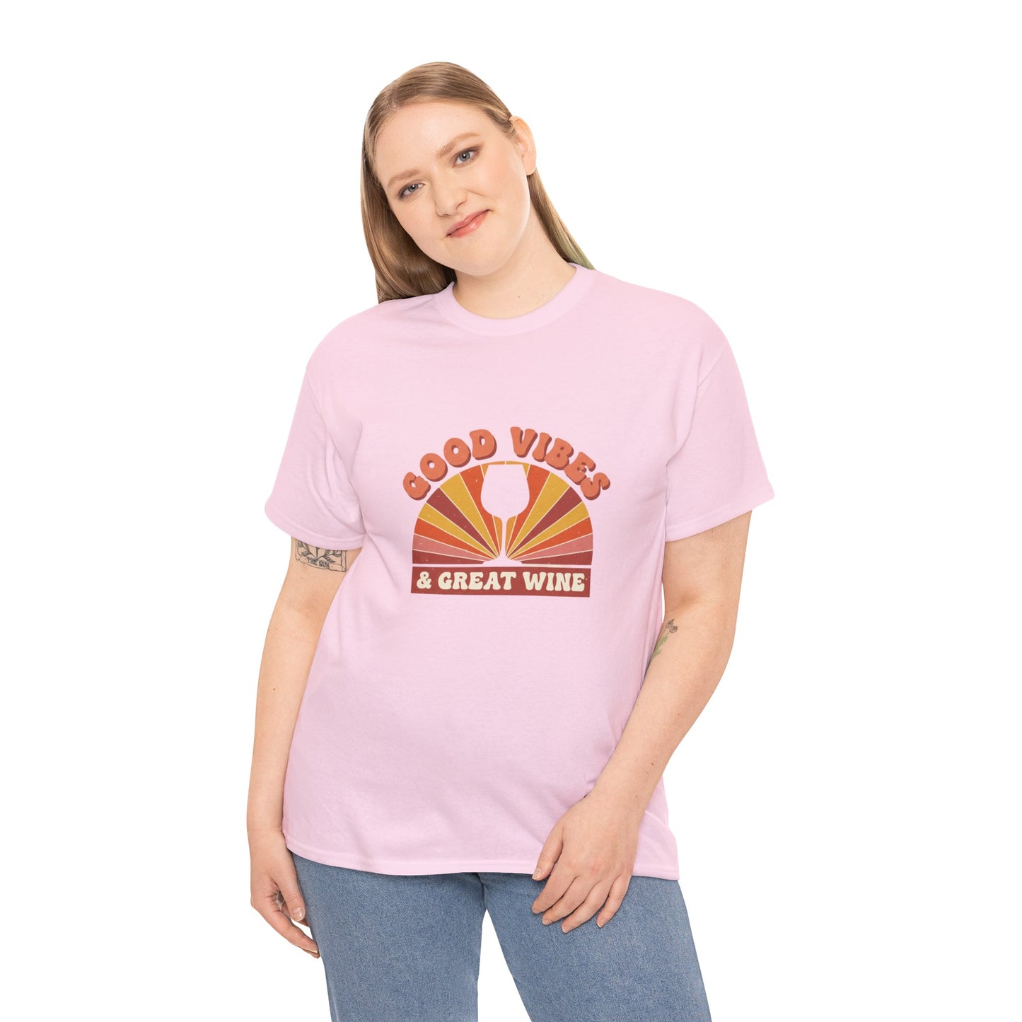 Person wearing pink T-shirt with a vintage graphic that states "good vibes and great wine" and white background
