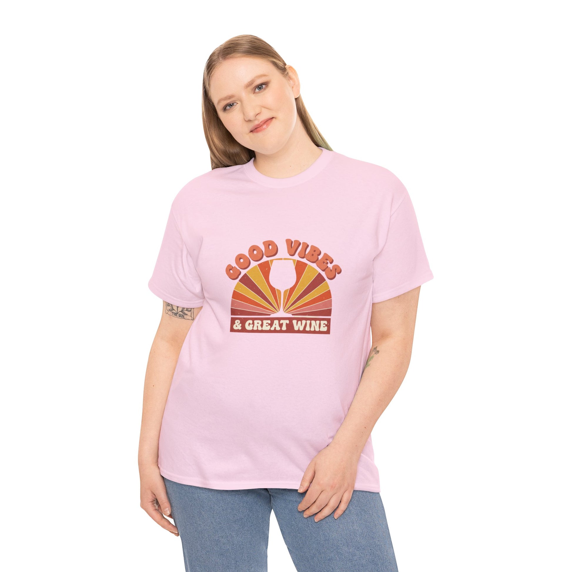 Person wearing pink T-shirt with a vintage graphic that states "good vibes and great wine" and white background